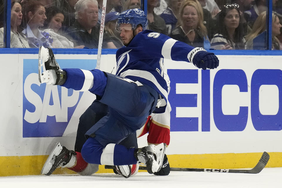 Florida Panthers center Sam Reinhart takes down Tampa Bay Lightning defenseman Mikhail Sergachev (98) during the third period in Game 4 of an NHL hockey Stanley Cup first-round playoff series, Saturday, April 27, 2024, in Tampa, Fla. (AP Photo/Chris O'Meara)