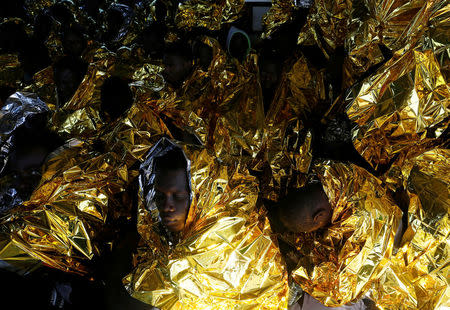 Migrants rest on the deck of the Malta-based NGO Migrant Offshore Aid Station (MOAS) ship Phoenix after being rescued from a rubber dinghy in the central Mediterranean in international waters some 15 nautical miles off the coast of Zawiya in Libya, April 14, 2017. REUTERS/Darrin Zammit Lupi TPX IMAGES OF THE DAY