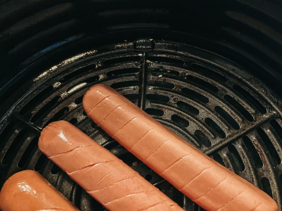 hot dogs cooking in an air fryer