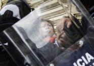 A woman pleads with the riot police who are arresting a protester in downtown Mexico City September 13, 2013. (REUTERS/Henry Romero)