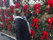 In this Saturday, Dec. 7, 2019 photo, Sandy Parsons looks over some Christmas wreaths for sale at her stand at the Capitol Market in Charleston, W.Va. Parsons never received her order of 350 trees this year from a North Carolina farm, citing a short supply. Instead, she was sent a few much-smaller trees to sell at her lot. Christmas trees are in tight supply again this year across the United States, depending upon location and seller, as the industry continues bouncing back from the Great Recession. (AP Photo/John Raby)