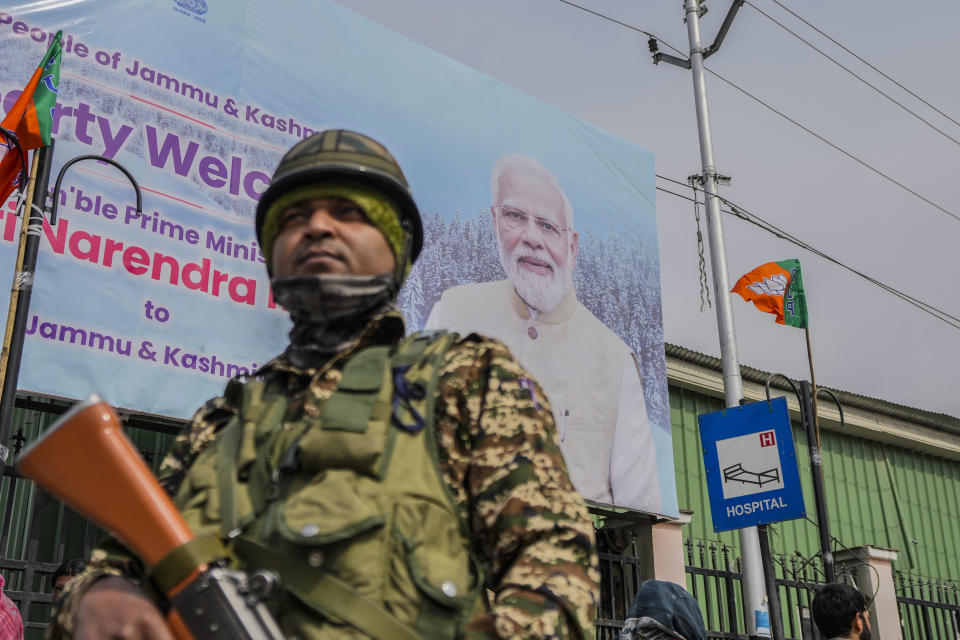 A paramilitary soldier guards near a billboard ahead of Indian Prime Minister Narendra Modi's visit to Srinagar, Indian controlled Kashmir, Wednesday, March 6, 2024. Modi is scheduled to address a public rally in Srinagar on Thursday. (AP Photo/Mukhtar Khan)