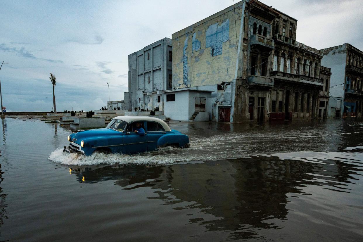 An old American car passes through a flooded street in Havana, Cuba on Sept. 28, 2022, after the passage of hurricane Ian.