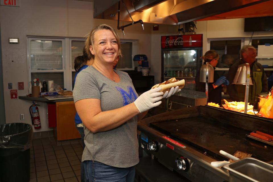 Shannon Marshall works the grill at at the Middletown football game during the first round playoff game against Moses Brown.