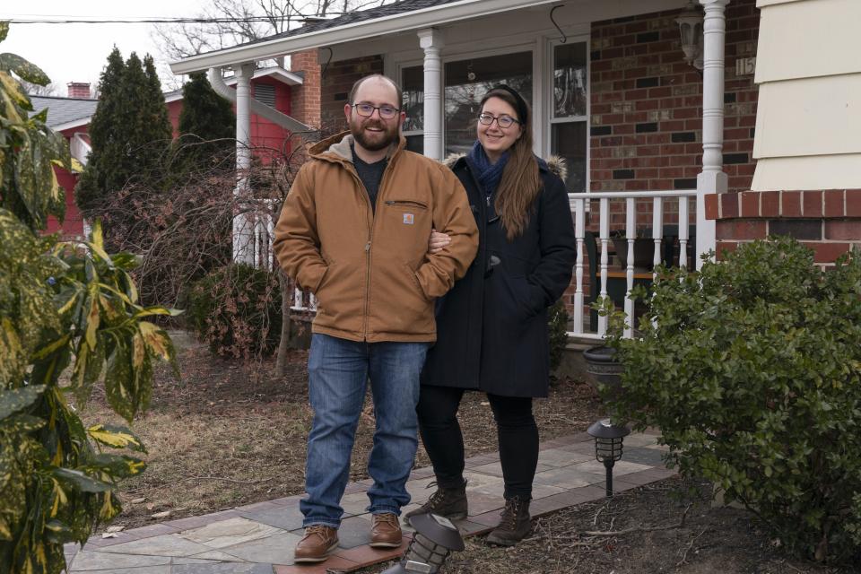 Ethan Miller and Rachel Mandelbaum pose for a portrait outside their home in Silver Spring, Md., Friday, Jan., 21, 2022. Tax filing season starts Monday and people can expect the task to be more cumbersome than usual this year thanks to an overloaded and understaffed IRS workforce and new complications from pandemic-related programs. (AP Photo/Jacquelyn Martin)