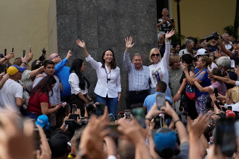 La lideresa de la oposición María Corina Machado, a la izquierda, y el candidato presidencial opositor Edmundo González, al centro, saludan a simpatizantes después de un evento de oración, el domingo 21 de julio de 2024, en Caracas. (AP Foto/Matias Delacroix)