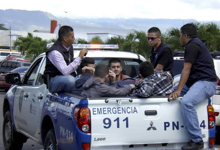 Policemen escort five Syrian men after they were detained at Toncontin international airport in Tegucigalpa, Honduras, November 18, 2015. Honduran authorities have detained five Syrian nationals who were trying to reach the United States using stolen Greek passports, but there are no signs of any links to last week's attacks in Paris, police said. The Syrian men were held late on Tuesday in the Honduran capital, Tegucigalpa, on arrival from Costa Rica, and had been planning to head to the border with neighboring Guatemala. The passports had been doctored to replace the photographs with those of the Syrians, police said. REUTERS/Stringer EDITORIAL USE ONLY. NO RESALES. NO ARCHIVE.