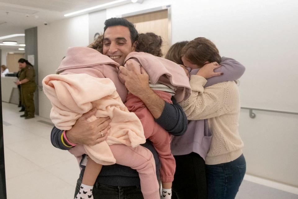 An Israeli family is reunited with released Israeli hostages shortly after their arrival in Israel on November 24, after being held hostage by the Palestinian militant group Hamas in the Gaza Strip, at an unknown location in Israel, in this handout picture released by the Israeli Prime Minister's Office on November 25, 2023.