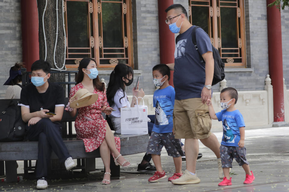 People wearing face masks to protect against the new coronavirus visit a shopping district in Beijing, Sunday, July 19, 2020. China on Sunday reported another few dozen of confirmed cases of the coronavirus in the northwestern city of Urumqi, raising the total in the country's most recent local outbreak to at least 30. (AP Photo/Andy Wong)