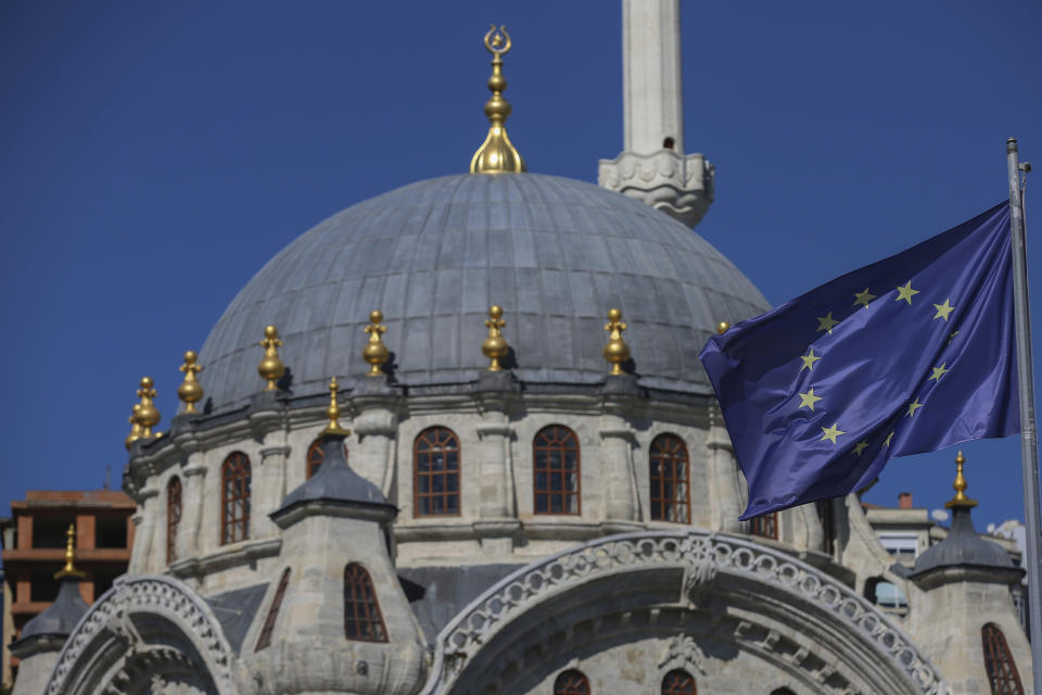 FILE - In this Thursday, Oct. 12, 2017 file photo, a European Union flag is seen in front of Nispetiye Mosque in Istanbul. Beset by a weak currency and tension with the United States, Turkey is reaching out to Europe in an attempt to shore up relations with major trading partners despite years of testy rhetoric and a stalled bid for EU membership. The overtures by Turkish President Recep Tayyip Erdogan, who has harshly criticized Germany and other European nations in the past, are part of a diplomatic campaign to capitalize on international unease over U.S. President Donald Trump and American tariff disputes. (AP Photo/ Emrah Gurel, file)