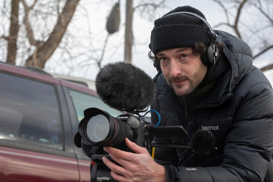 Dorian Degoutte, 31, a filmmaker from Vierzon, France, records footage for his art film inside Pal’s Auto Parts in Detroit on Dec. 28, 2022. Degoutte and his family believe that his grandfather Papuche’s essence is still in the car, making it one of the reasons why he decided to make the art film, in honor of his grandfather and his attachment to his car that was handed down to him over 10 years ago.