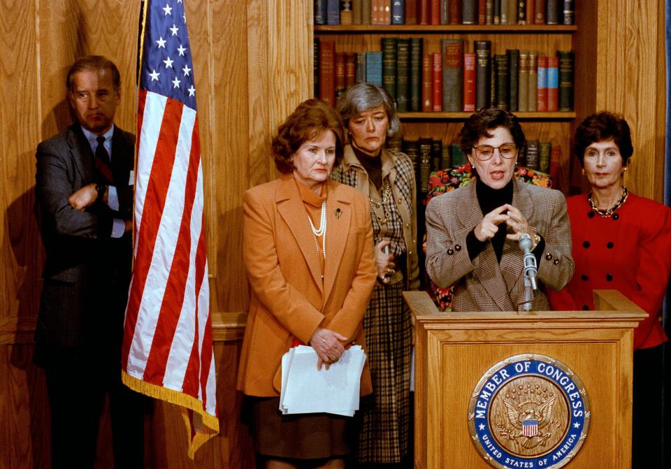 Sen. Joe Biden, left, stands behind a flag as Sen. Barbara Boxer (D-Calif.), second from right, along with other congresswomen meet reporters on Capitol Hill, Feb. 24, 1993.