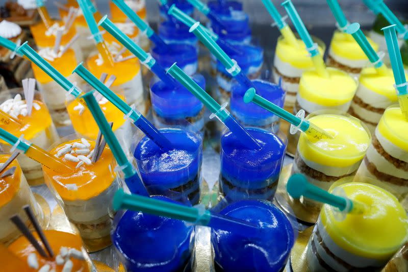 Una pastelería en Hungría exhibe postres con motivos de vacunas contra el COVID-19, diferenciándola por vivos colores. Picture taken April 16, 2021. REUTERS/Bernadett Szabo