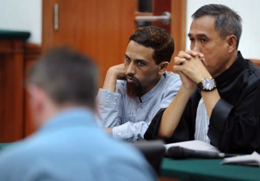 Indonesian Muslim militant and suspected Bali bomber Umar Patek (C) looks on next to his unidentified defense counsel (R) during his trial in Jakarta April 5. Patek, is facing murder charges for the 2002 Bali bombing and five other counts, including bomb-making and illegal firearms possession