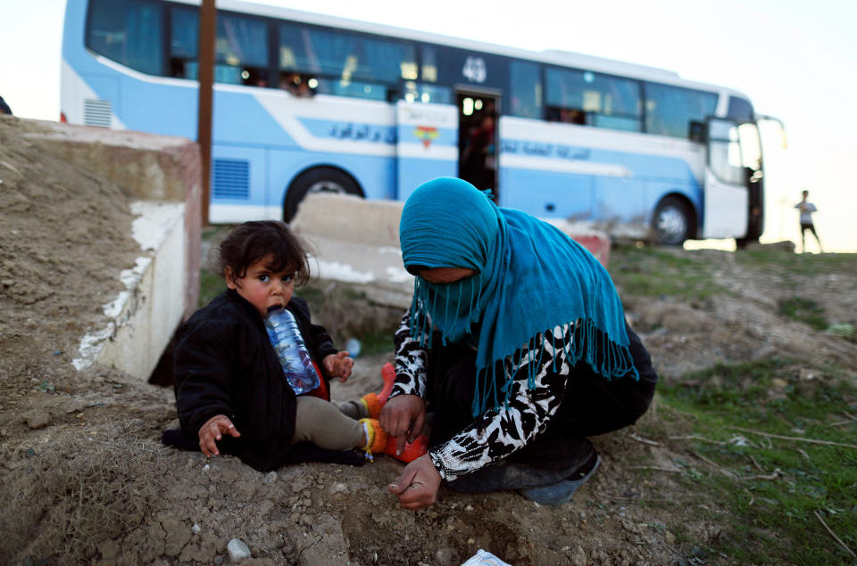 <p>A woman who just fled a village controlled by Islamic State militants checks her daughter as she sits in front of a bus before heading to the camp at Hamam al-Alil, south of Mosul, Iraq, Feb. 22, 2017. (Zohra Bensemra/Reuters) </p>