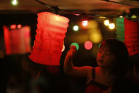 A girl touches a lantern at an outdoor restaurant during the Chinese Mid-Autumn Festival in Hong Kong Sunday, Sept. 30, 2012. Like ancient Chinese poets, Hong Kong people appreciate the beauty of the full moon in the Mid-Autumn Festival. (AP Photo/Vincent Yu)