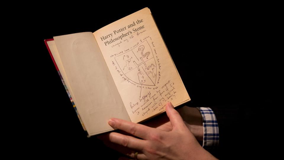 Photo by Matt Dunham/AP/REX/Shutterstock Sotheby's director of the department of printed books and manuscripts Dr Philip Errington poses for photographers with a first edition copy of the first Harry Potter book 