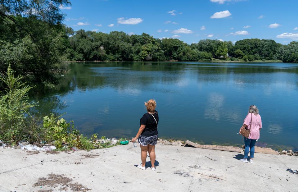 Searchers look at a large pond, Tuesday, July 12, 2022, during a hunt for Kyle Moorman, who went missing with his three children a week ago. This area, near Bluff Road and West Troy Avenue is a spot Moorman liked to go fishing. 