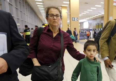 U.S. citizen Lori Berenson and her son Salvador Apari walk at the Jorge Chavez International Airport prior to leaving Peru, in Callao, December 2, 2015. REUTERS/Guadalupe Pardo