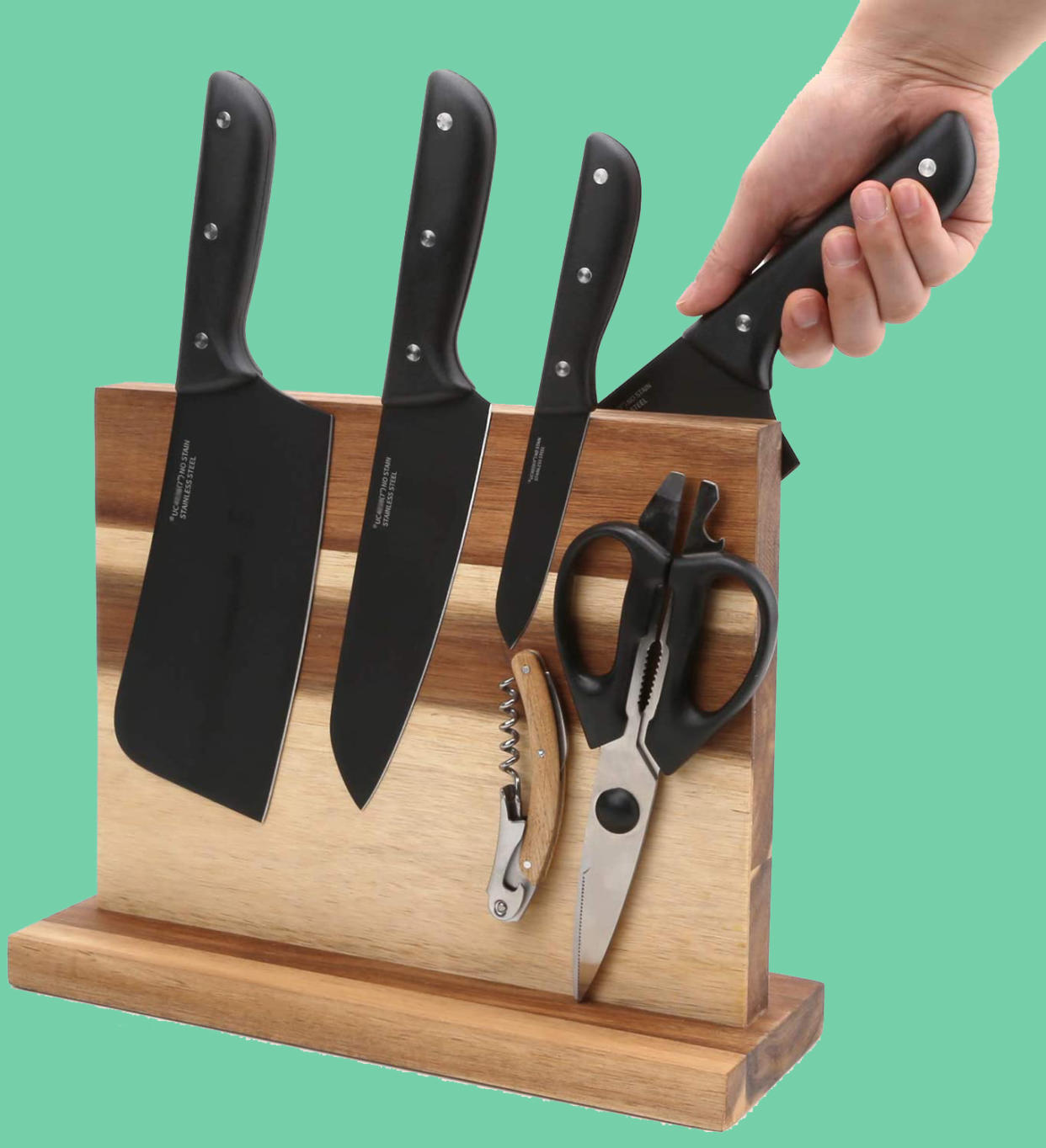 Knives and a pair of scissors on the side of a magnetic knife block holder. 