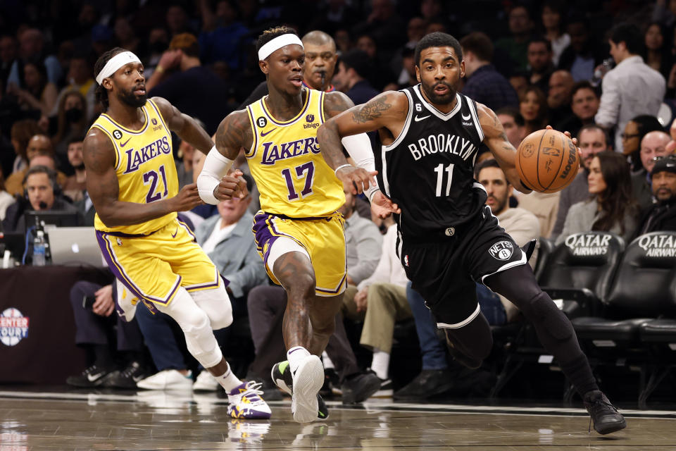 NEW YORK, NEW YORK - JANUARY 30: Kyrie Irving #11 of the Brooklyn Nets dribbles as Patrick Beverley #21 and Dennis Schroder #17 of the Los Angeles Lakers defend during the second half  at Barclays Center on January 30, 2023 in the Brooklyn borough of New York City. The Nets won 121-104. NOTE TO USER: User expressly acknowledges and agrees that, by downloading and/or using this photograph, User is consenting to the terms and conditions of the Getty Images License Agreement. (Photo by Sarah Stier/Getty Images)