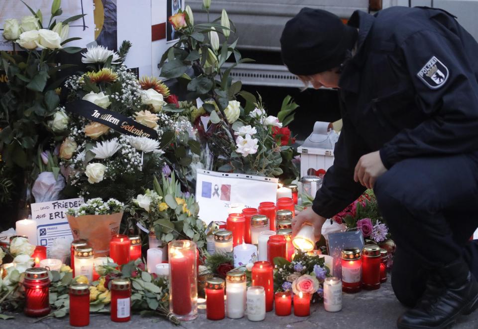 FILE - In this Dec. 20, 2016 file photo a police officer lights a candle in Berlin, Germany the day after a truck ran into a crowded Christmas market nearby. German prosecutors say they've detained a Tunisian man they think may have been involved in last week's truck attack on a Christmas market in Berlin. Federal prosecutors said Wednesday Dec. 28, 2016 the 40-year-old was detained during a search of his home and business. (AP Photo/Matthias Schrader,file)