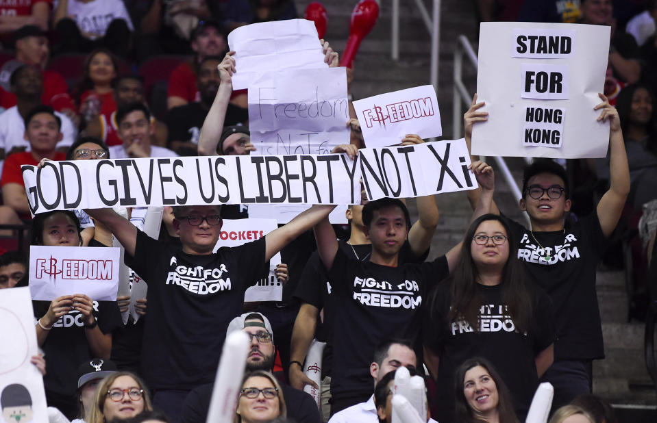 Fans hold signs about Hong Kong during the second half of an NBA basketball game between the Houston Rockets and the Milwaukee Bucks, Thursday, Oct. 24, 2019, in Houston. (AP Photo/Eric Christian Smith)