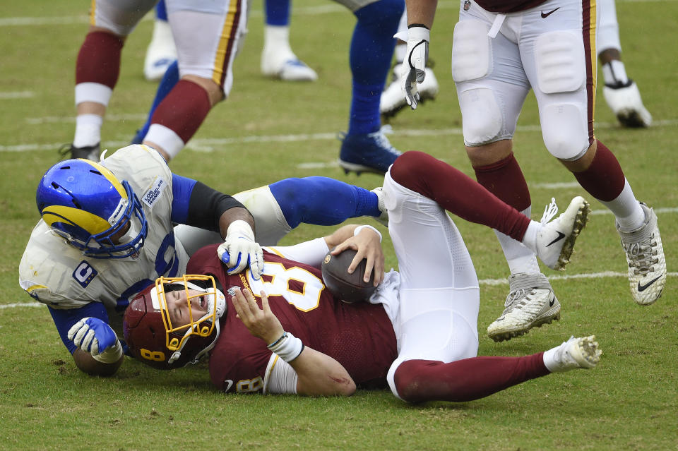 Kyle Allen of the Washington Football Team is sacked by Aaron Donald. (Photo by Patrick McDermott/Getty Images)