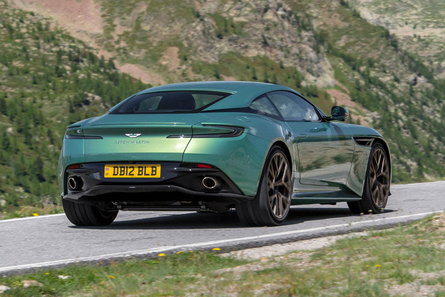 Aston Martin DB12 driving on mountain road – rear quarter