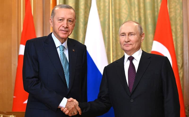 Russian President Vladimir Putin (R) shakes hands with Turkish President Recep Tayyip Erdogan during a meeting in the Black Sea resort of Sochi. -/Kremlin/dpa
