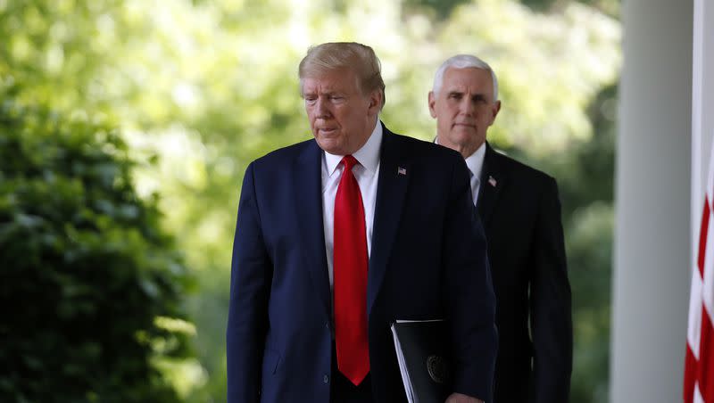 President Donald Trump and Vice President Mike Pence walk from the Oval Office to speak in the Rose Garden of the White House on April 27, 2020, in Washington.