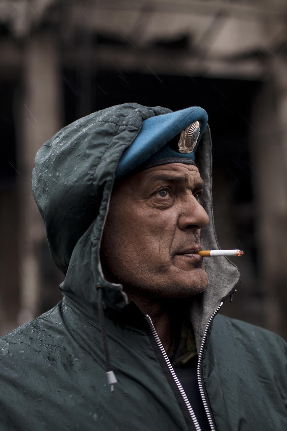 Dima, a member of a volunteer self defense group, smokes a cigarette during a rainfall in Kiev's Independence Square, Ukraine, Sunday, March 16, 2014. In a referendum watched closely around the world, residents in Ukraine's strategic Crimean Peninsula voted Sunday on whether to demand greater autonomy or split off and seek to join Russia. (AP Photo/David Azia)