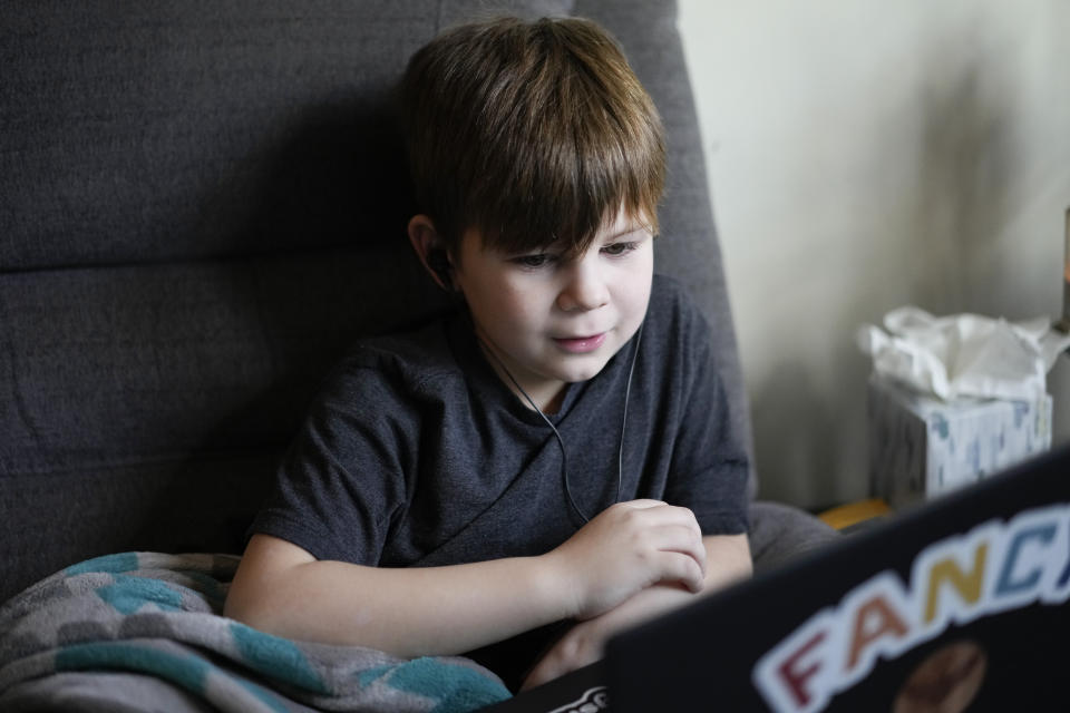 Phoenix Blalack, 6 , works with a tutor on his laptop in his Indianapolis home, Tuesday, March 7, 2023. (AP Photo/AJ Mast)