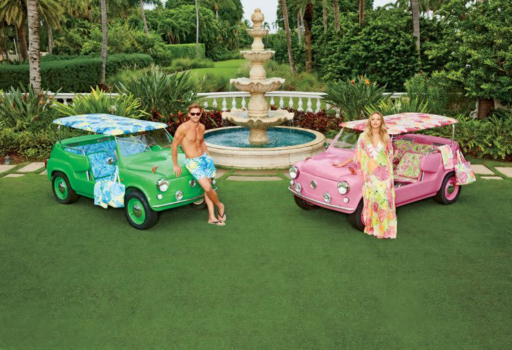 Tanned models lean against his and hers island cars