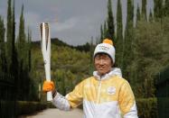 Olympics - Lighting Ceremony of the Olympic Flame Pyeongchang 2018 - Ancient Olympia, Olympia, Greece - October 24, 2017 Former South Korea footballer Park Ji-sung poses with the Olympic torch with the flame during the Olympic flame lighting ceremony for the Pyeongchang 2018 Winter Olympics REUTERS/Alkis Konstantinidis