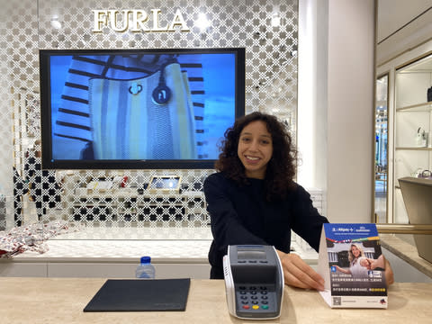 The salesperson welcomes Chinese travelers to use Alipay for payment at Designer Outlet Roermond in the Netherlands (Photo: Business Wire)