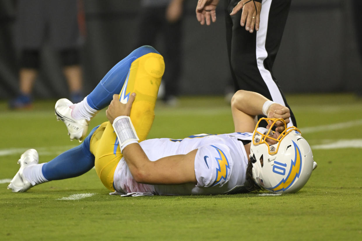 Los Angeles Chargers quarterback Justin Herbert (10) was slow to get up after being hit in the fourth quarter by Kansas City Chiefs defensive end Mike Danna and left the game for one play, during an NFL football game, Thursday, Sept. 15, 2022 in Kansas City, Mo. (AP Photo/Reed Hoffmann)