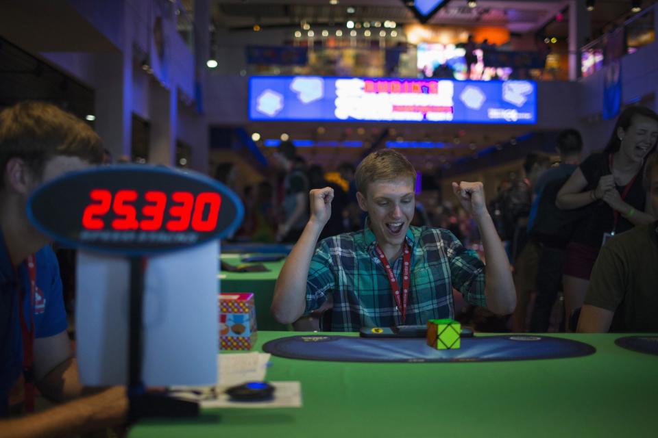 A participant gestures as he competes at the National Rubik's Cube Championship at Liberty Science Center in Jersey City, New Jersey