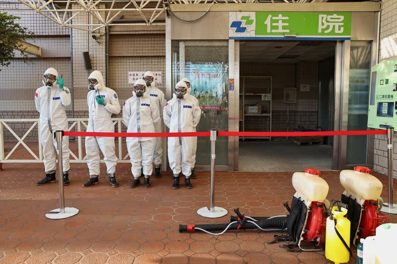 Soldiers prepare to spray disinfectant outside the Taoyuan General Hospital in Taoyuan