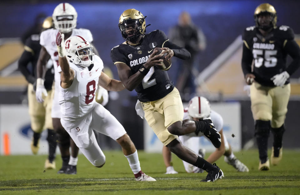 Colorado quarterback Shedeur Sanders runs for a short gain past Stanford linebacker Tristan Sinclair during the first half of an NCAA college football game Friday, Oct. 13, 2023, in Boulder, Colo. (AP Photo/David Zalubowski)