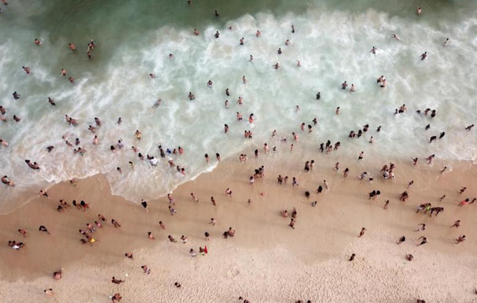 Varias personas se bañan guardando la distancia social en la playa de Ipanema de Río. (Foto: Pilar Olivares / Reuters).