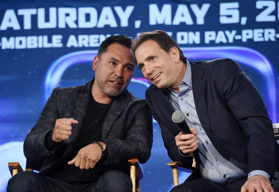 Oscar De La Hoya speaks with Tom Loeffler during a news conference at Microsoft Theater at L.A. Live in Los Angeles. (Getty Images)
