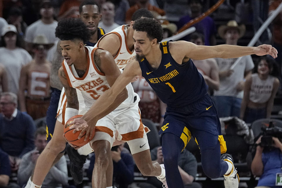 Texas forward Dillon Mitchell (23) and West Virginia forward Emmitt Matthews Jr. (1) reach for a loose ball during the second half of an NCAA college basketball game in Austin, Texas, Saturday, Feb. 11, 2023. (AP Photo/Eric Gay)