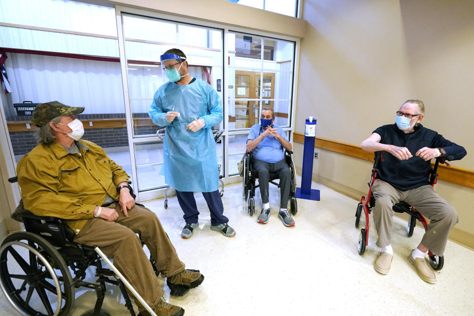 FILE - In this Jan. 9, 2021, file photo, Brent Myers, a CVS pharmacist, second from left, speaks with residents of the Mississippi State Veterans Home in Jackson, Miss., about their receiving the Pfizer covid vaccination. The coronavirus vaccines have been rolled out unevenly across the U.S., but some states in the Deep South have had particularly dismal inoculation rates. (AP Photo/Rogelio V. Solis, File)