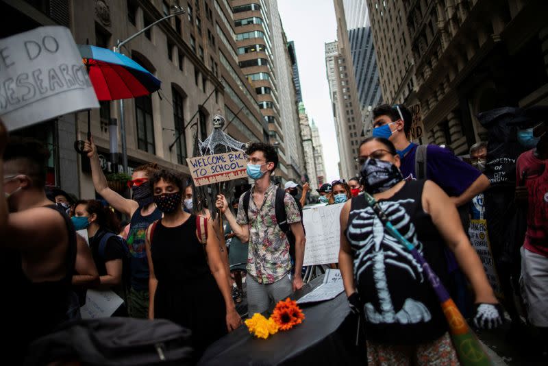 People carry a fake coffin as symbol of a student dead by COVID-19 as they take part in a march and rally during the National Day of Resistance to schools re-opening in New York