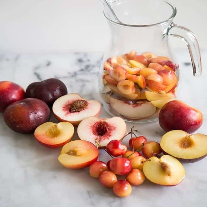 A pitcher and stone fruit.