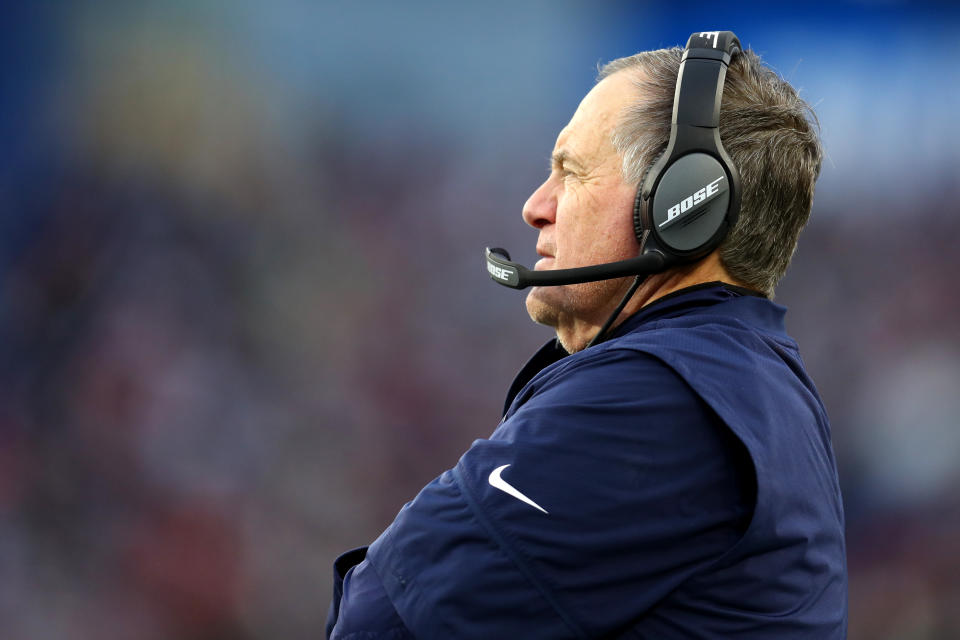 Bill Belichick stares pensively at the football field.