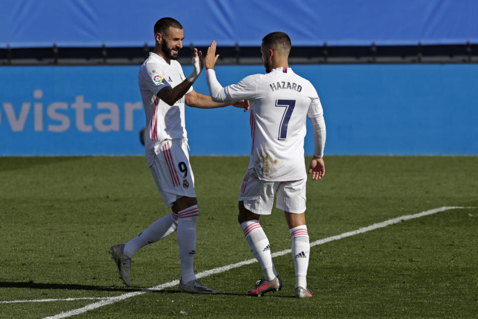 El atacante de Real Madrid Eden Hazard, derecha, celebra con su compañero Karim Benzema tras anotar el primer gol del equipo contra Huesca en un partido de La Liga española el sábado, 31 de octubre del 2020. (AP Foto/Manu Fernandez)