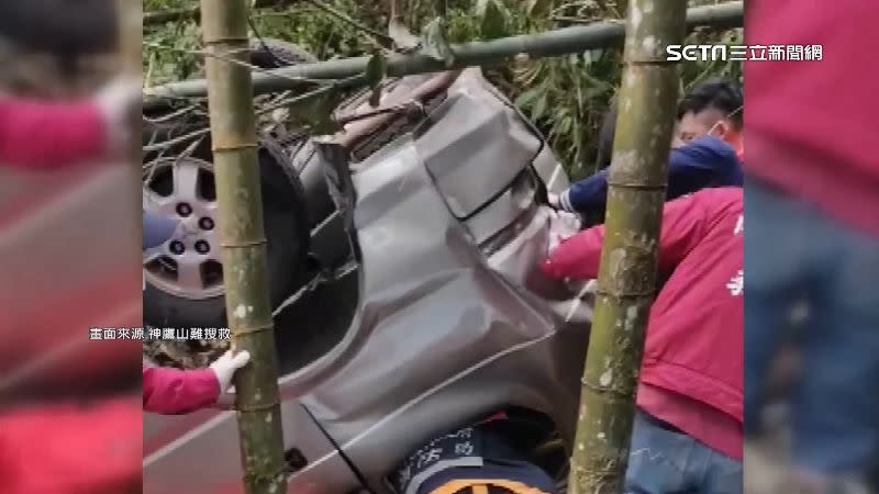 休旅車車身多處嚴重變形並卡在竹林間。（圖／畫面來源　神鷹山難搜救）