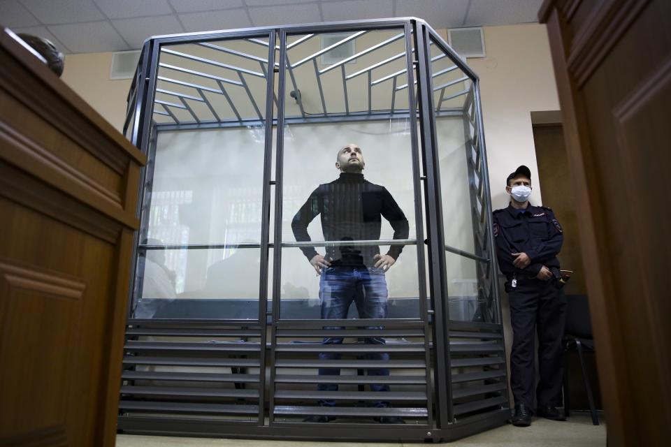 FILE - Andrei Pivovarov, the former head of the Open Russia movement, stands behind glass during a court session in Krasnodar, Russia, on June 2, 2021. Pivovarov, serving four years for running a banned political organization, must clean his solitary cell for several hours a day and listen to a recording of prison regulations, says his wife, Tatyana Usmanova. (AP Photo, File)